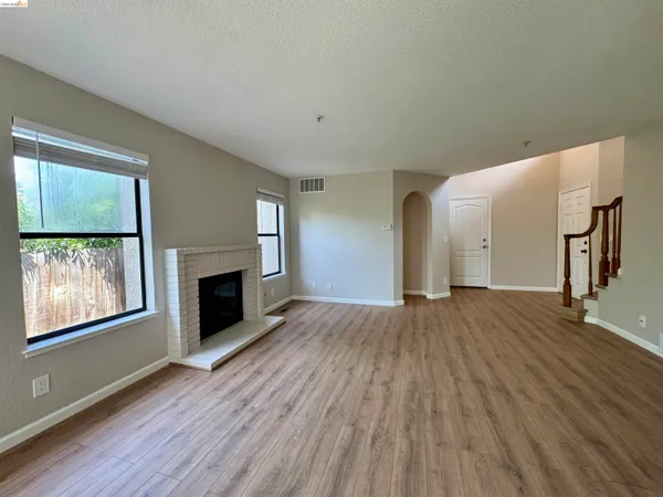 a view of an empty room with a fireplace and a window