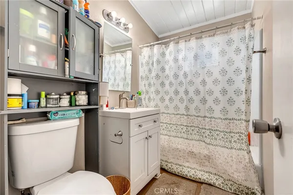 a bathroom with a granite countertop sink a toilet and shower