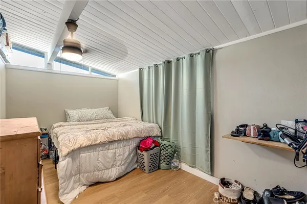 a bedroom with a bed and a dresser next to a window