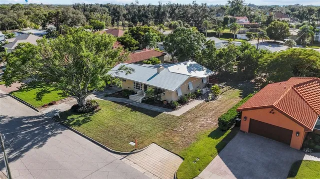an aerial view of a house with a yard swimming pool patio and lake view