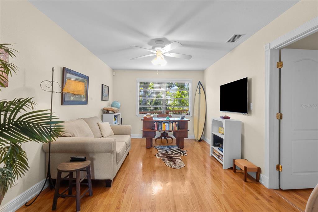 420 Pensacola Road Venice, FL 34285 - Photo 6 of 40 a living room with furniture floor to ceiling window hardwood floor and a flat screen tv