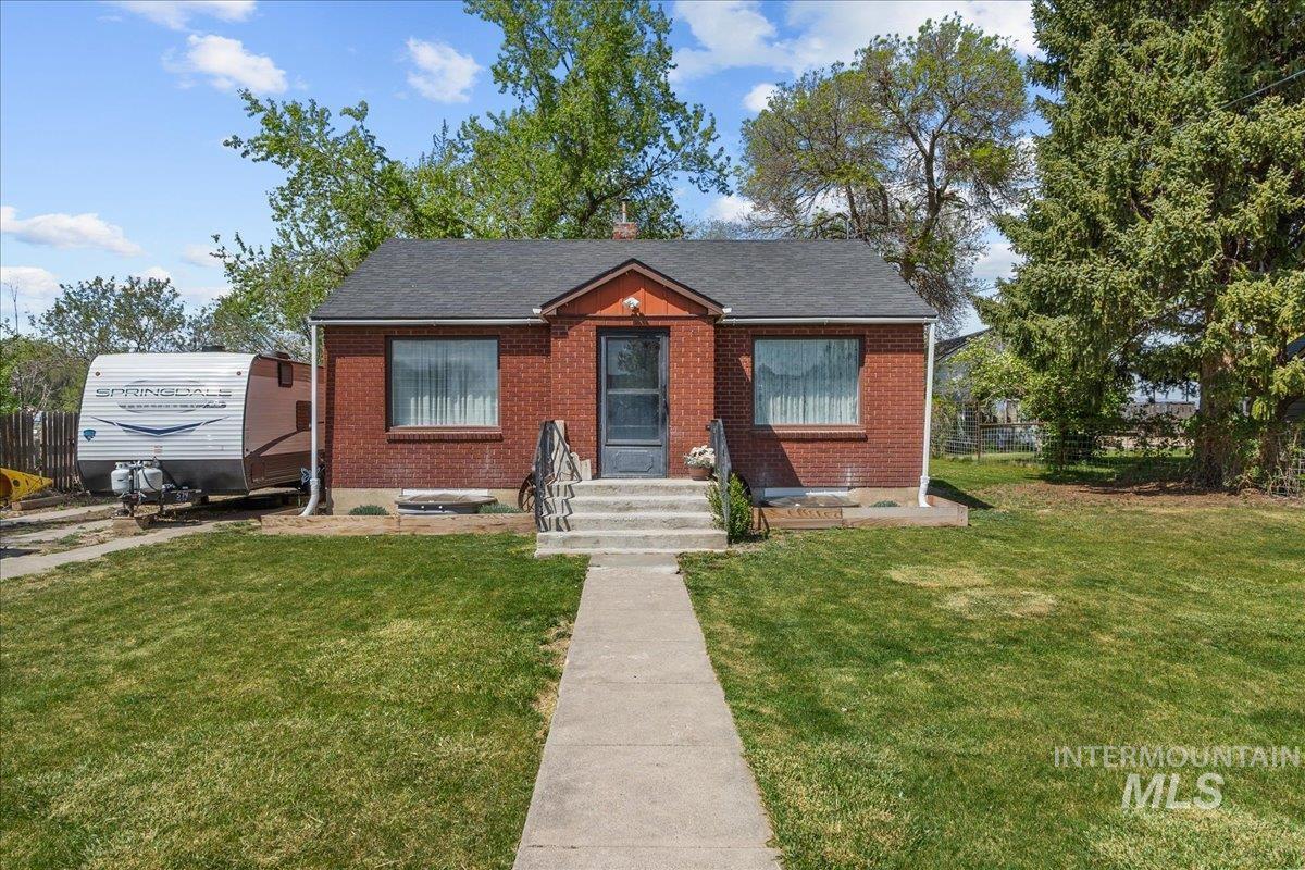 1958 East 1775 South Gooding, ID 83330 - Photo 2 of 49 Brick exterior with a dark roof and a concrete walkway leading to the entrance