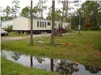 235 South 2nd Street Santa Rosa Beach, FL 32459 - Photo 1 of 2 a view of a house with a yard and a pond