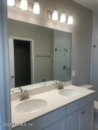 a bathroom with a double vanity sink toilet and shower