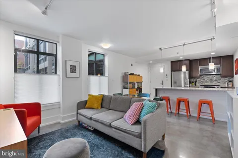 a living room with furniture and a kitchen view