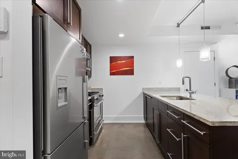 a kitchen with stainless steel appliances granite countertop a refrigerator stove and microwave