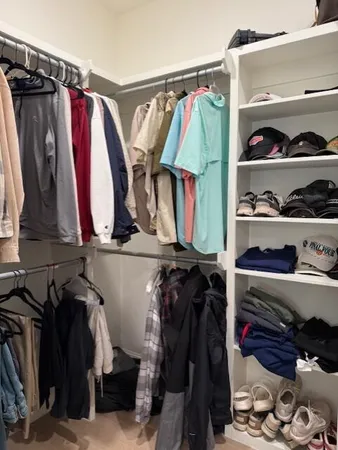 a view of walk in closet with clothes and shoes