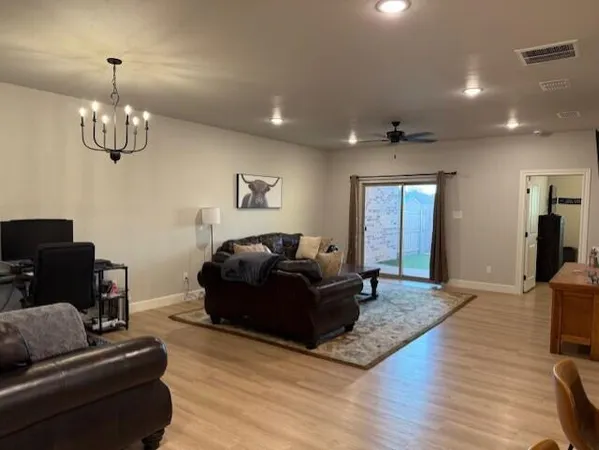 a living room with furniture wooden floor and chandelier