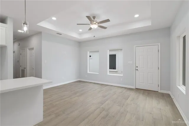 a kitchen with stainless steel appliances granite countertop a sink a stove a refrigerator and white cabinets