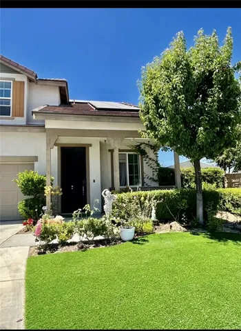 a front view of a house with a yard and a tree