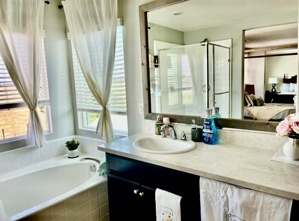 31509 Tuberose Road Murrieta, CA 92563 - Photo 34 of 41 a bathroom with a double vanity sink a tub and a mirror