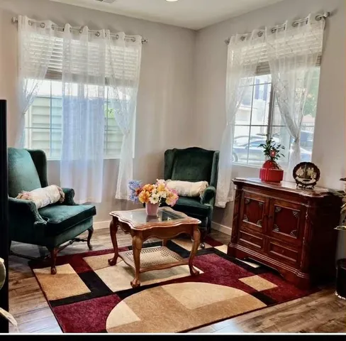 a living room with furniture and a floor to ceiling window