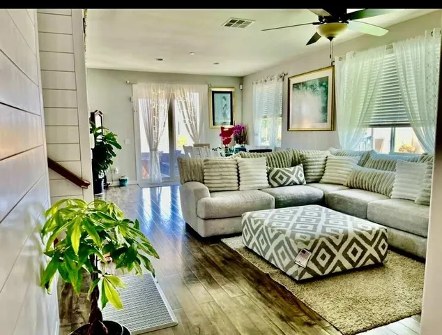 a living room with furniture plant and a chandelier