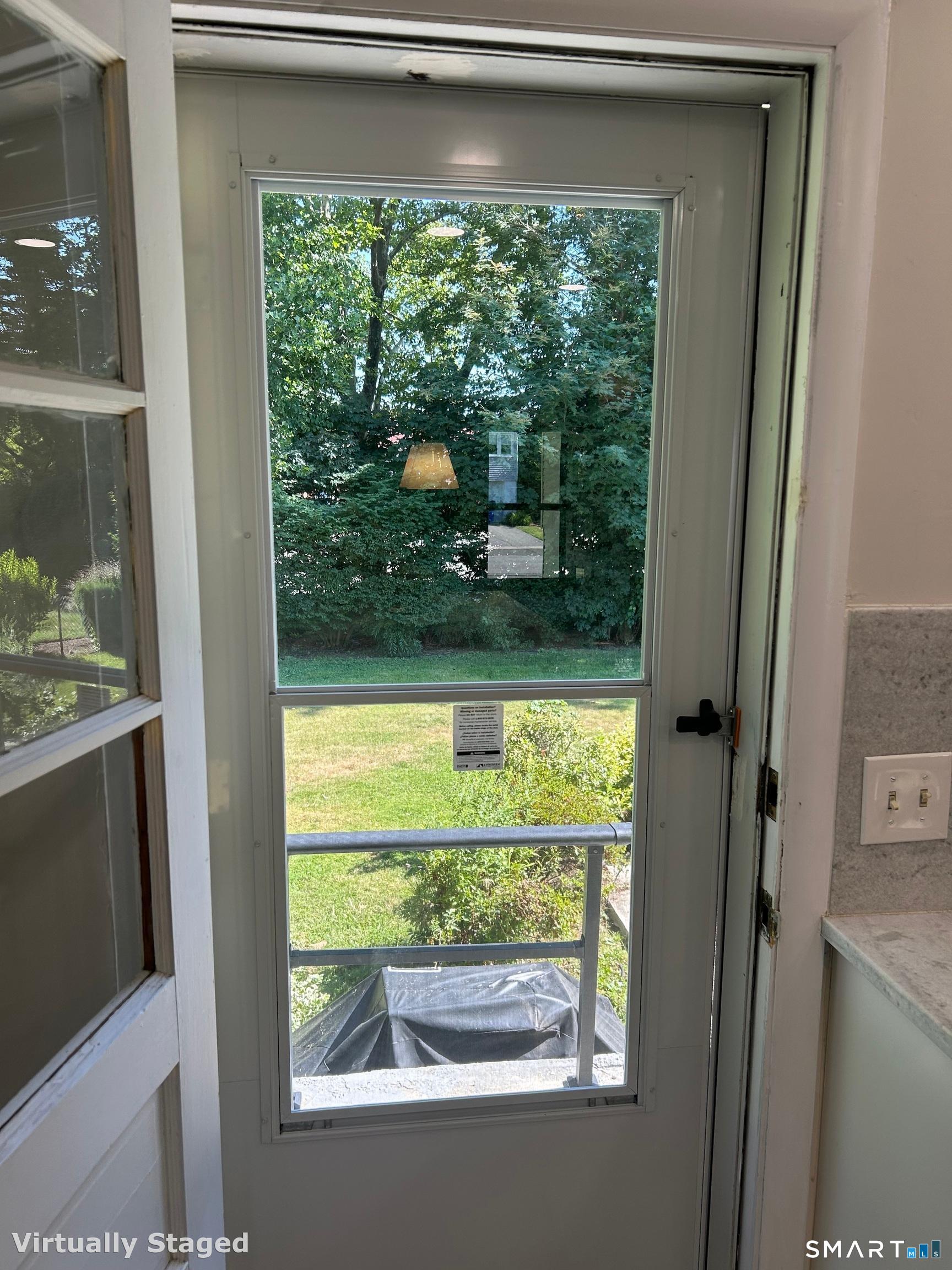 99 Lyman Road West Hartford, CT 06117 - Photo 18 of 39 Back door off the kitchen lets in beautiful light and has a great view of the backyard and patio.