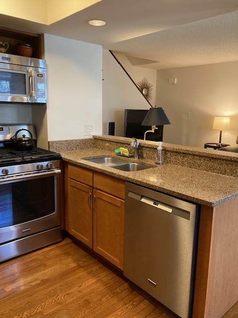 1154 Inverrary Lane, Unit 1154 Deerfield, IL 60015 - Photo 6 of 19 a kitchen with stainless steel appliances granite countertop a stove a sink and a microwave