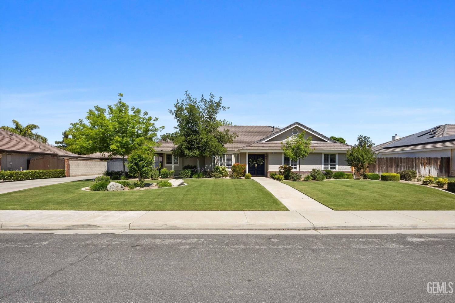 Undisclosed Address Bakersfield, CA 93314 - Photo 2 of 58 a front view of a house with a yard and garage