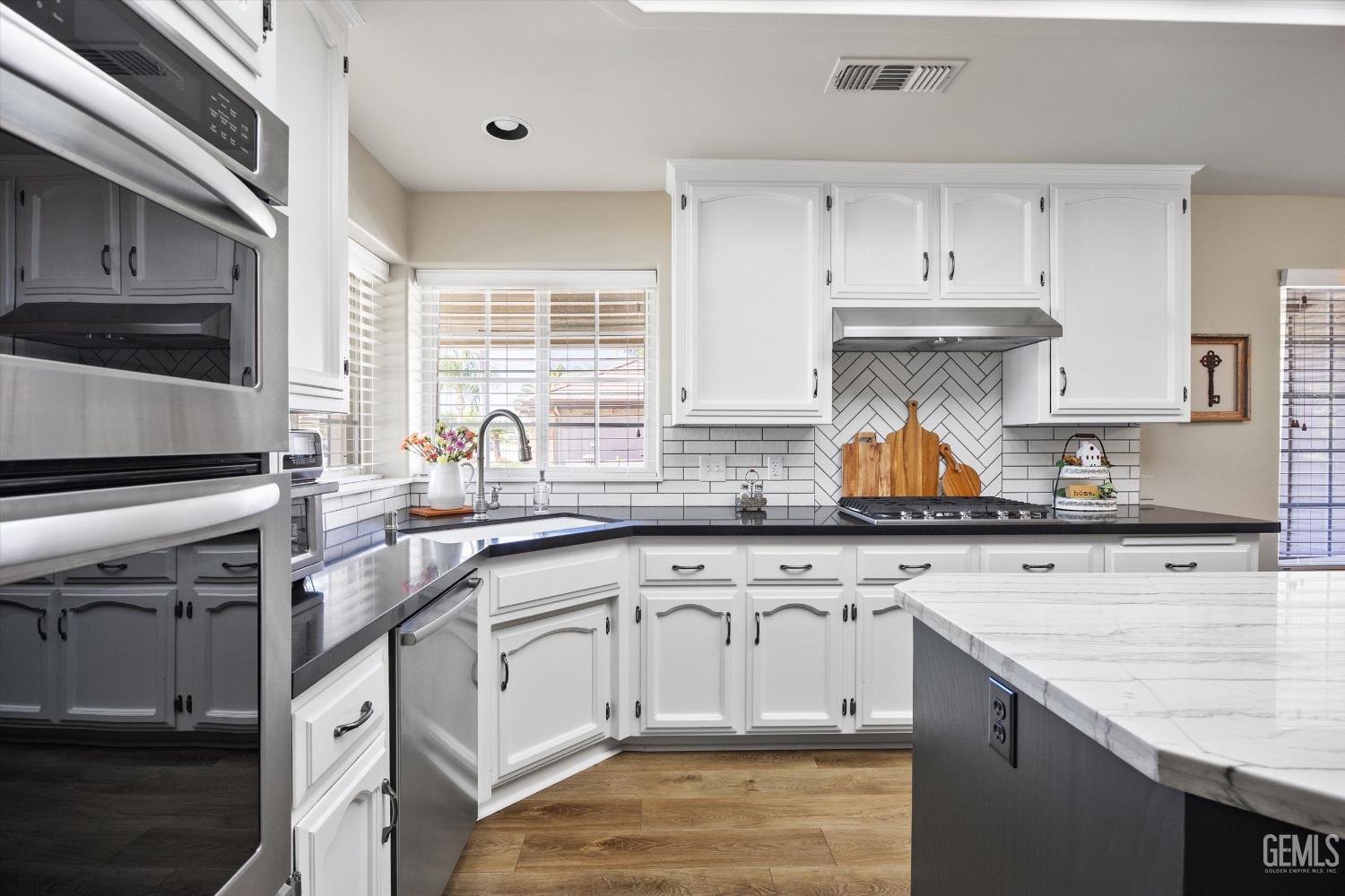 Undisclosed Address Bakersfield, CA 93314 - Photo 22 of 58 a kitchen with granite countertop white cabinets and white appliances