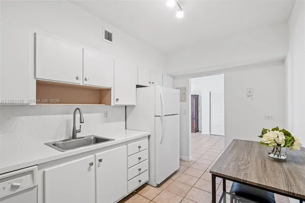 a kitchen with stainless steel appliances kitchen island granite countertop a sink refrigerator and cabinets