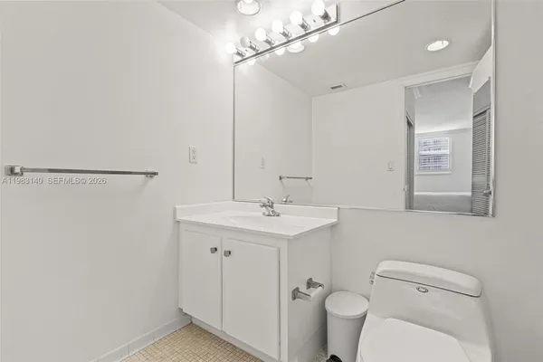 a view of a balcony with a couple of cars parked in front of a house