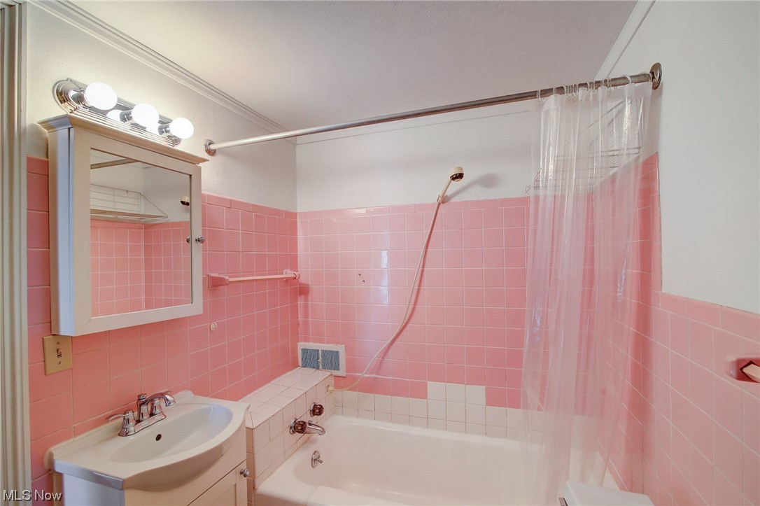 45555 North Ridge Road Amherst, OH 44001 - Photo 32 of 36 Upstairs bathroom featuring shower / tub combo with curtain, vanity with extensive cabinet space, and tile walls
