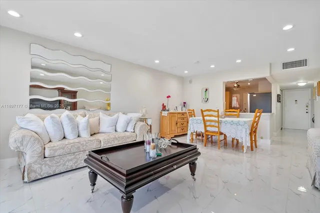 a living room with furniture kitchen view and a table