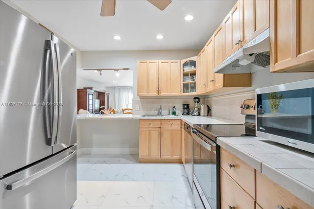 a kitchen with stainless steel appliances granite countertop a refrigerator and a sink