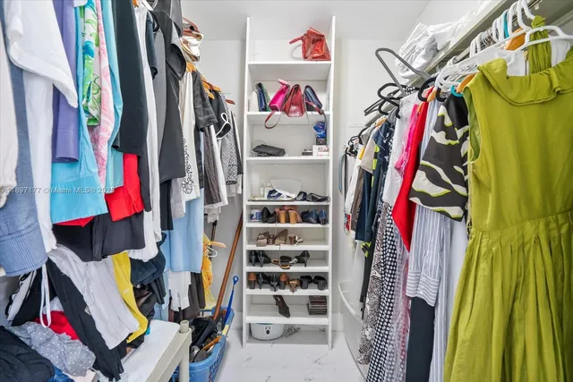 a view of walk in closet with clothes