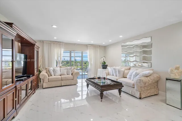 a living room with furniture a flat screen tv and a window