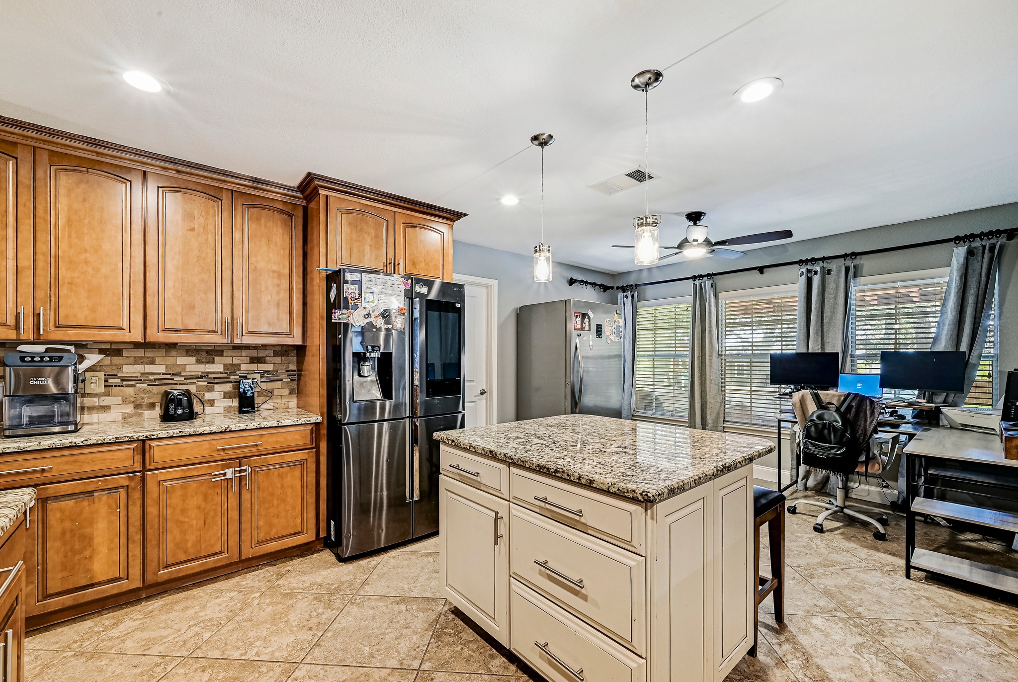 104 North Sumac Lane Georgetown, TX 78633 - Photo 15 of 40 A well-appointed kitchen features rich wood cabinetry, granite countertops, and modern pendant lighting over a functional center island.