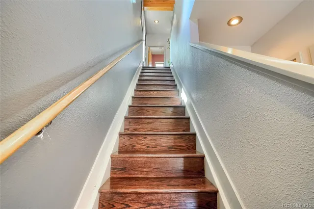 a living room with stainless steel appliances wooden floor and a fireplace