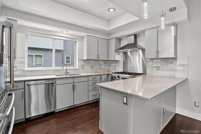 a kitchen with granite countertop a sink a counter space stainless steel appliances and cabinets