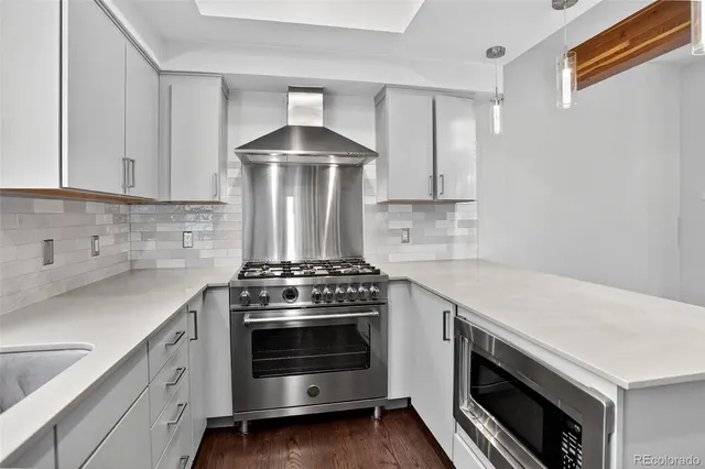 a kitchen with kitchen island a counter top space wooden floor and stainless steel appliances