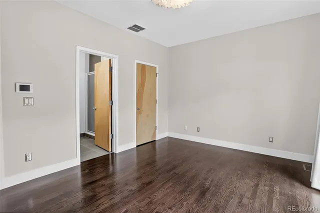 an empty room with wooden floor and closet