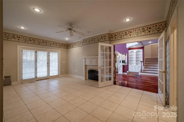 a view of a livingroom with a fireplace cabinet and windows