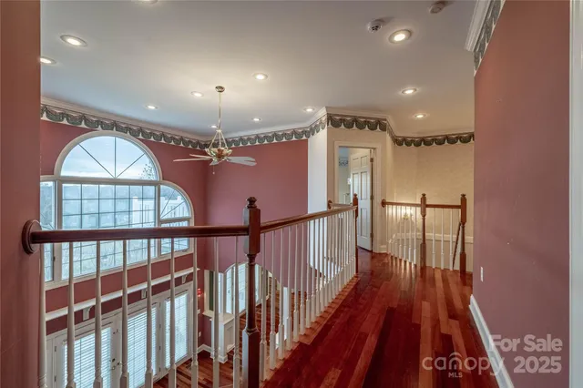 a view of an empty room with wooden floor fireplace and a window