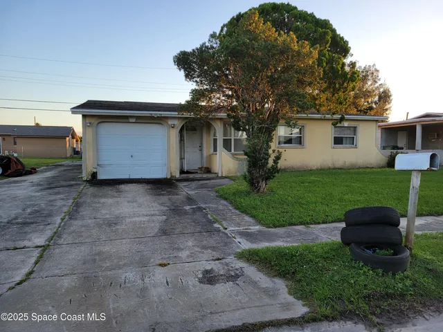a white house that has a tree in front of it