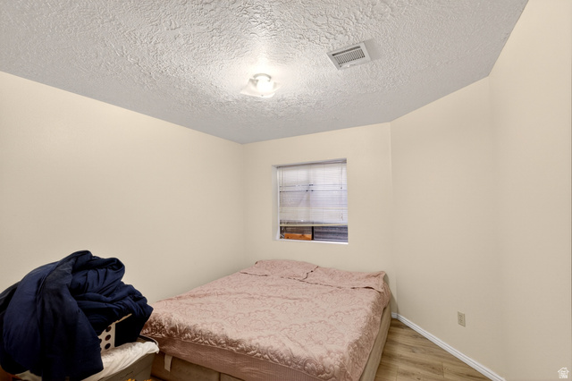 161 West 950 South, Unit Q1 St. George, UT 84770 - Photo 31 of 37 Bedroom featuring wood finished floors and a textured ceiling