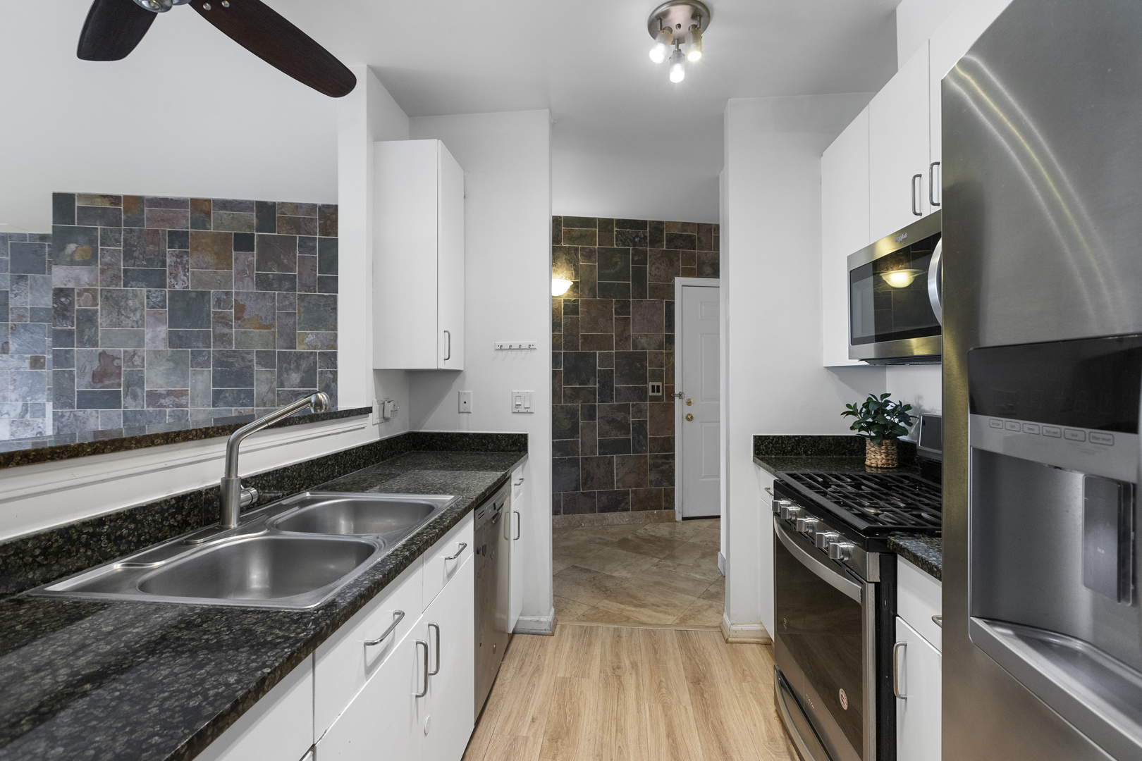 7738 North Sheridan Road, Unit 4R Chicago, IL 60626 - Photo 6 of 18 a kitchen with granite countertop a sink stove and refrigerator