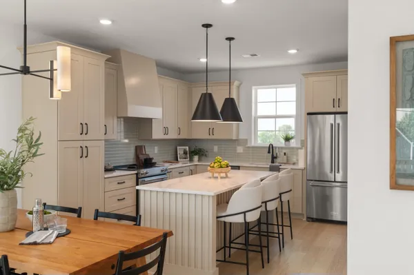 a kitchen with stainless steel appliances granite countertop a sink a stove a refrigerator and island with wooden floor