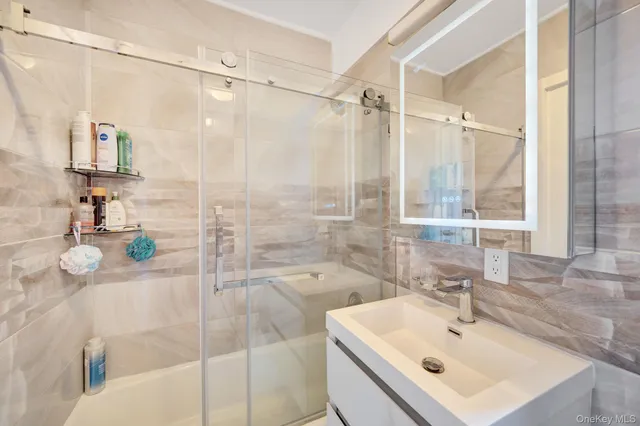 a bathroom with a sink mirror and a shower