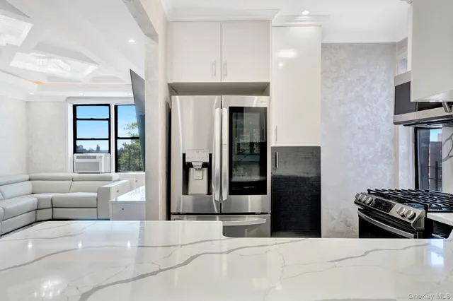 a kitchen with stainless steel appliances kitchen island granite countertop a refrigerator and a stove top oven