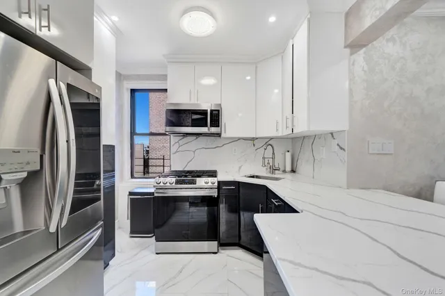 a kitchen with stainless steel appliances a stove sink microwave and refrigerator