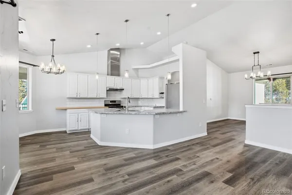 a large kitchen with kitchen island white cabinets and stainless steel appliances