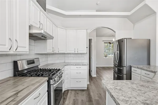 a kitchen with stainless steel appliances granite countertop a stove a refrigerator and a sink