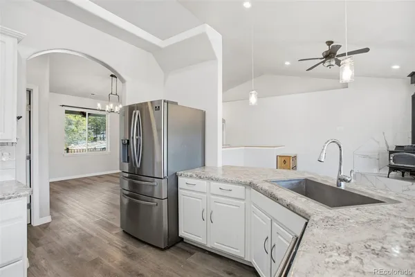 a kitchen with stainless steel appliances granite countertop a refrigerator a sink a stove and cabinets