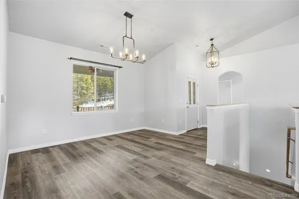 a view of empty room with wooden floor and ceiling fan