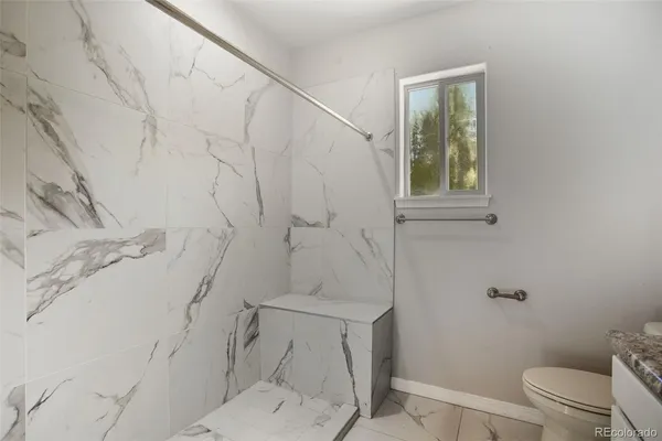 a bathroom with a toilet and a shower