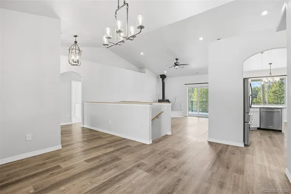 a view of a room with wooden floor staircase and a kitchen