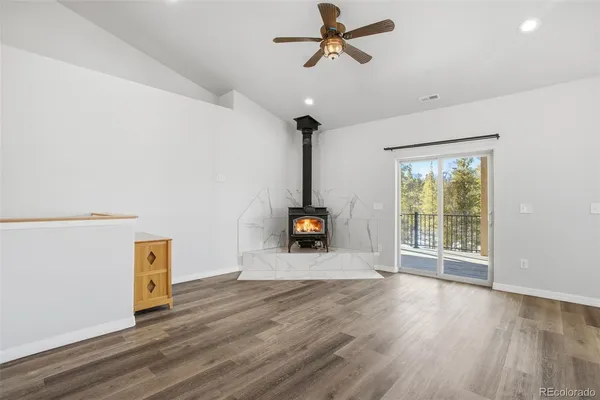 a view of a livingroom with wooden floor and a ceiling fan