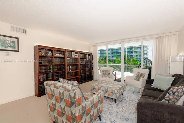 a living room with furniture a lamp and a large window
